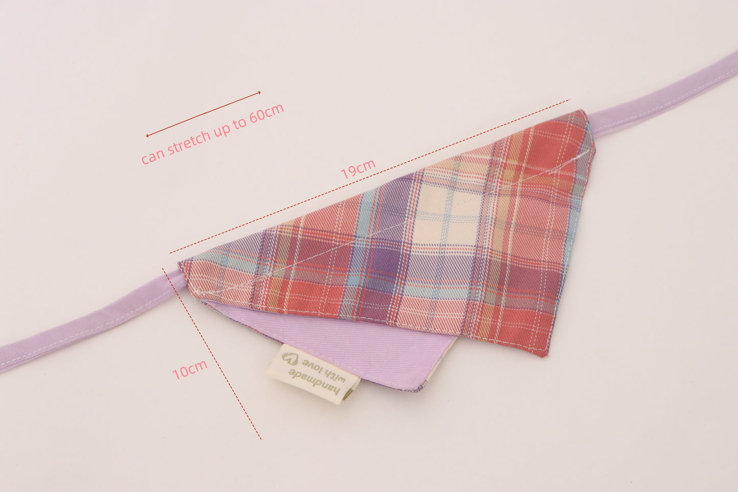 Plaid fabric triangle with purple strap and measurements on a light background